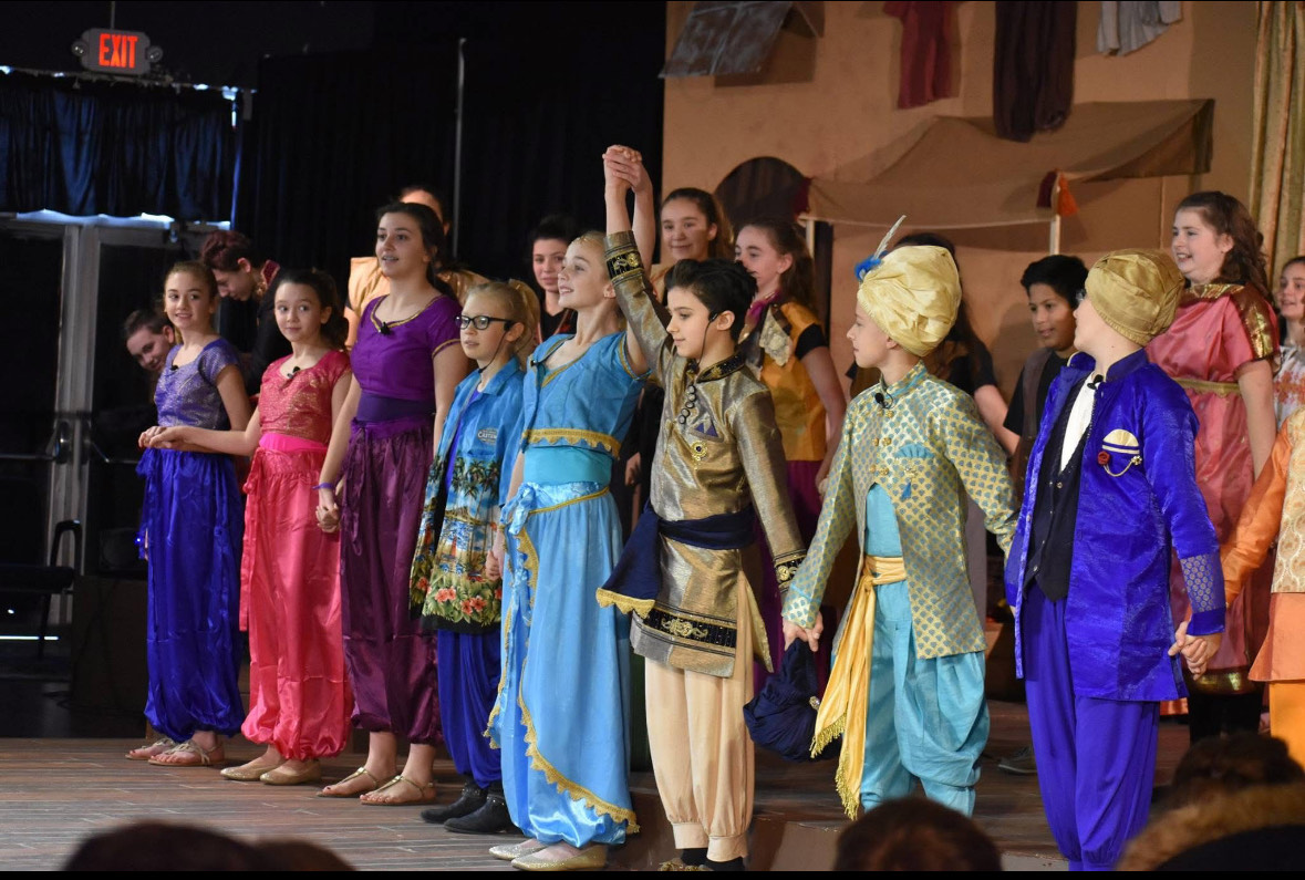 Student performers taking a bow on stage